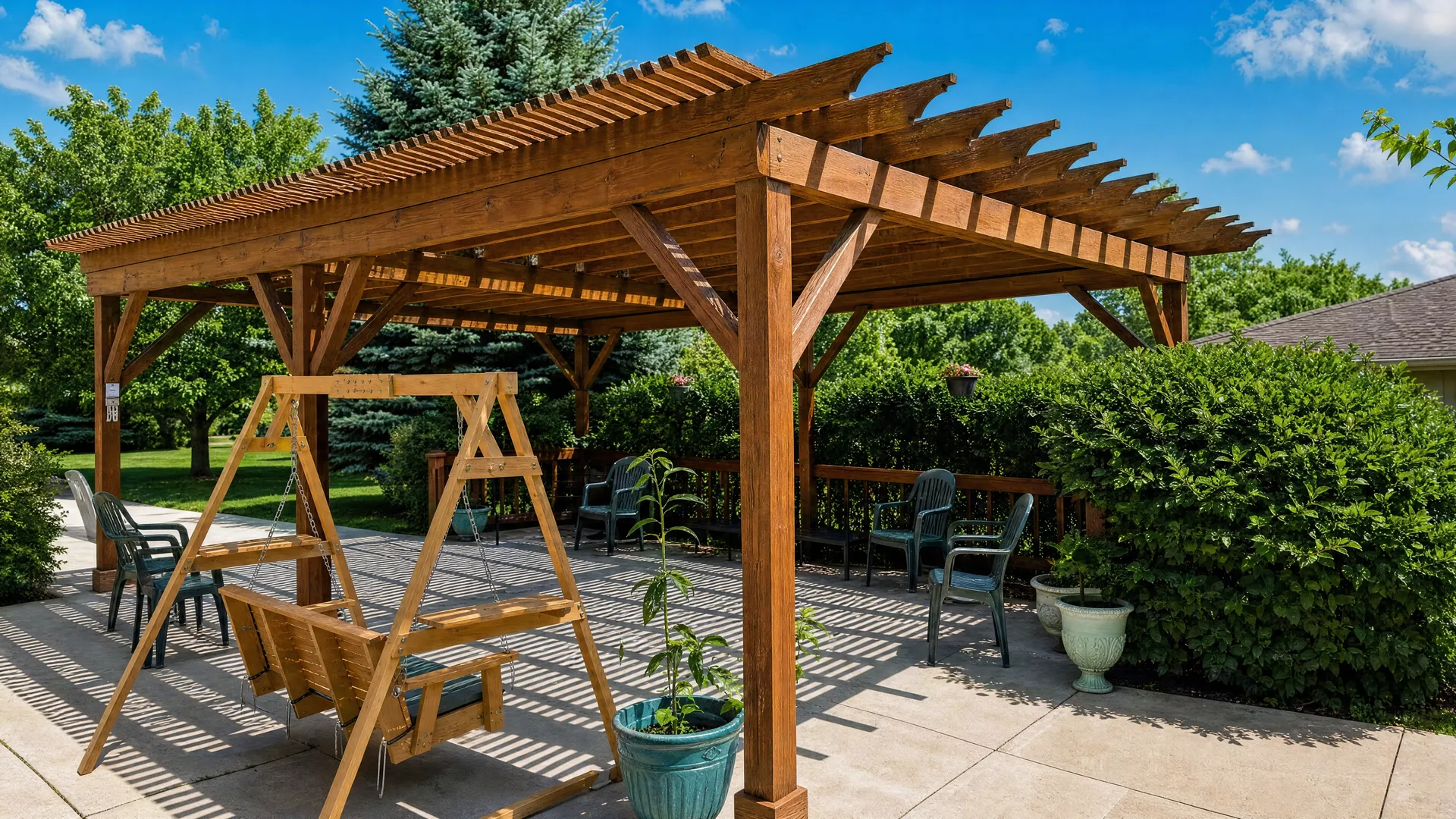 Pergola seating area with a swing and patio chairs at Nora Springs Care Center