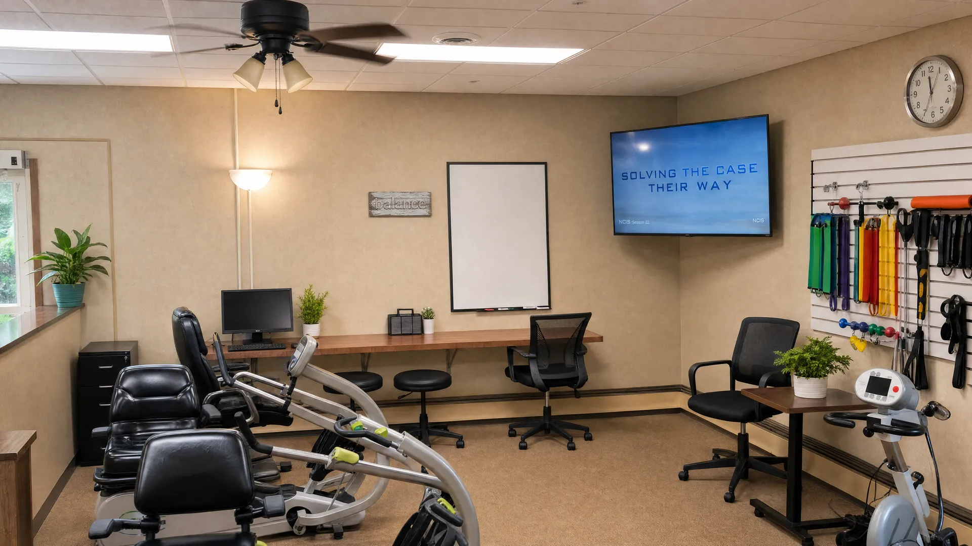 Rehabilitation gym with exercise equipment and a wall-mounted television at Nora Springs Care Center